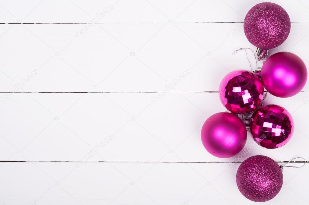 Christmas background. Pink Christmas ornaments on a white wooden