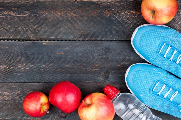 Sport concept. Sportschoenen, appels en fles water op oude wo — Stockfoto