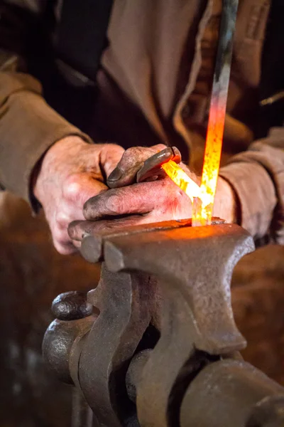 Blacksmith bending a hot metal rod — Stock Photo, Image