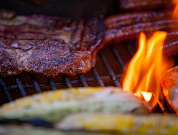 Hotdogs, steaks en zalm op een grill — Stockfoto