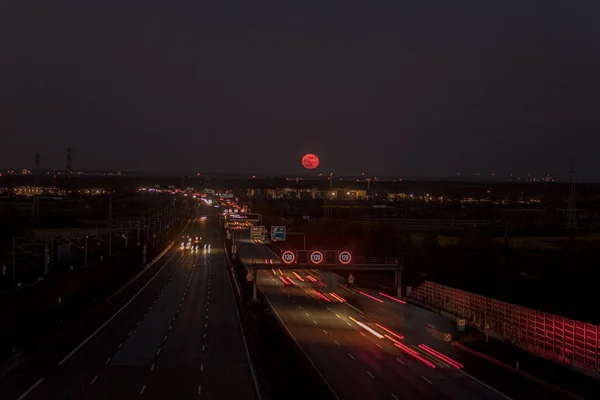 Nisan 2021 'de bir Alman otoyolunun üzerinde yükselen Pembe Ay' ın resmi