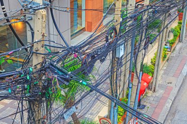 Bangkok 'un ana caddesinde gündüz vakti elektrik ve telefon kablolarının kaotik yönlendirmesi