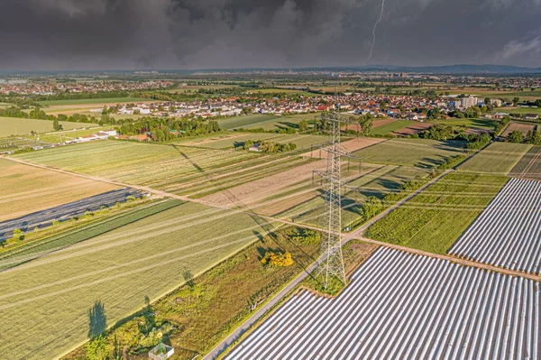 Panoramatický obraz vysokonapěťové silnice s vysokonapěťovými sloupy ve večerním světle a blížící se bouří — Stock fotografie