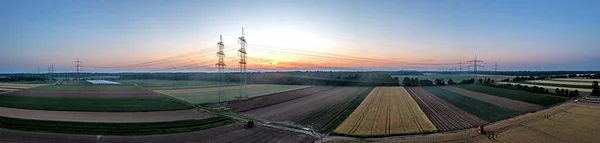 Panoramatický obraz elektrického vedení nad zemí při západu slunce v přísvitu — Stock fotografie