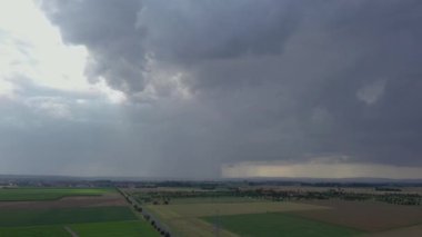 Kara üzerinde gündüz vakti dramatik bulut oluşumları olan gök gürültülü İHA videosu