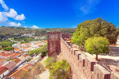 Silves kalesindeki arkeolojik harabeler ve kuleler. Algarve Portekiz 'de kırmızı taş duvarlar ve mavi gökyüzü..