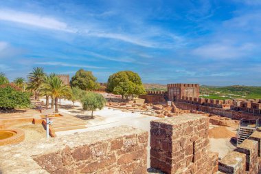 Silves kalesindeki arkeolojik harabeler ve kuleler. Algarve Portekiz 'de kırmızı taş duvarlar ve mavi gökyüzü..