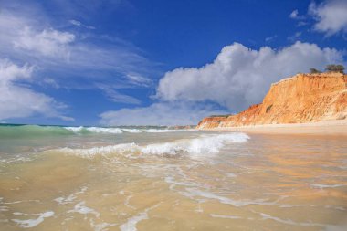 Geniş sahil, açık gökyüzü ve Algarve Portekiz 'deki Praia da Falesia' da yumuşak sörf.