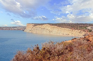 Dik kireçtaşı uçurumlarının manzarası ve Portekiz 'in Algarve kasabasındaki Luz köyü yakınlarındaki sakin deniz manzarası