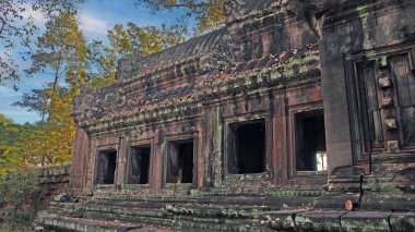 Ayrıntılı taş oymalar ve yosun kaplı duvarlar Angkor Wat Kamboçya 'nın kalıntıları.