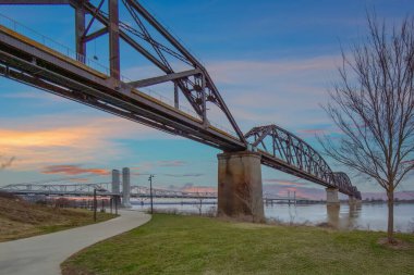 Ohio Nehri üzerindeki ikiz köprülerin altında Louisville Kentucky 'deki modern kablo köprü ve çelik yapı köprüsünü görüyoruz.