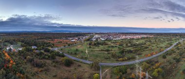Frankfurt yakınlarındaki Morfelden Walldorf 'un insansız hava aracı gökyüzü altında ufuk çizgisi ve sonbahar ormanı gösteriyor.