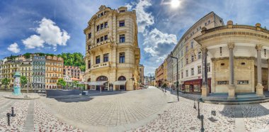Karlovy Vary Çek Cumhuriyeti 'nde güneşli bir günde merkez meydanı, süslü cephe dükkanları ve kafelerle gösteriliyor..