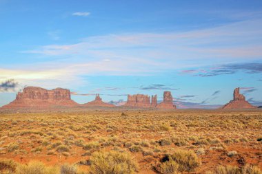 Anıt Vadisi 'nin geniş manzarası ikonik kumtaşı popoları ve yumuşak ışık altında açık çöl..