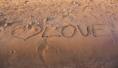 Kum üzerine aşk kelimesi.