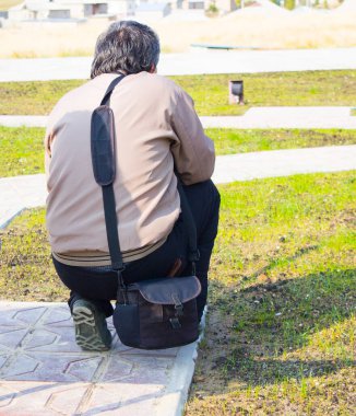 Bir adam sırtüstü oturuyor.