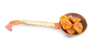 Beyaz arka planda izole edilmiş bir kaşık kurutulmuş kayısı.