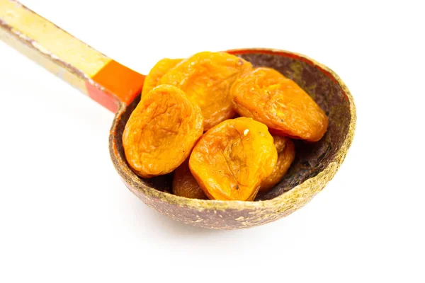 Beyaz arka planda izole edilmiş bir kaşık kurutulmuş kayısı.