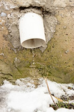 Arka planda boru olan eski taş duvar.