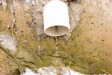 Arka planda boru olan eski taş duvar.