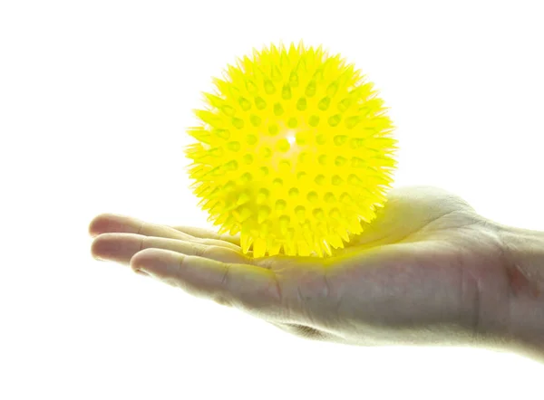 El ele tutuşan sarı oyuncak beyaz arka planda izole edilmiş.