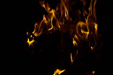 Siyah arkaplanda kıvılcımlar saçan ateş alevleri