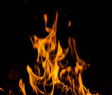 Siyah arkaplanda kıvılcımlar saçan ateş alevleri