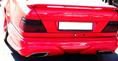 Kırmızı araba tekerleğinin arkasında ağır bulanık hareket var. (Beyazı Ayır.)