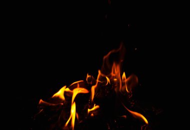 Siyah arkaplanda kıvılcımlar saçan ateş alevleri