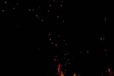 Siyah arkaplanda kıvılcımlar saçan ateş alevleri