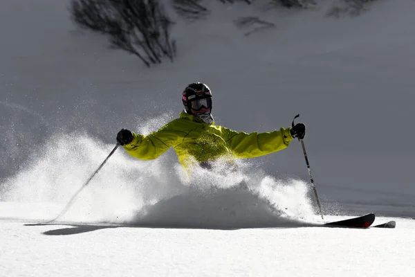 Ein Mann fährt mit Skiern einen schneebedeckten Hang hinunter — Stockfoto