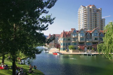 Hotels next to a park on the water in Kelowna, B.C. in Canada clipart