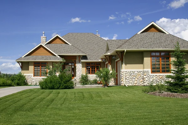 Single family home, with pristine lawn and blue sky background — Stock Photo, Image