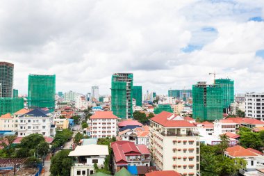 Phnom Penh şehrinin resmi. Mimaride, büyük binalarda, geleneksel evlerin yanında. İnşaat endüstrisi.
