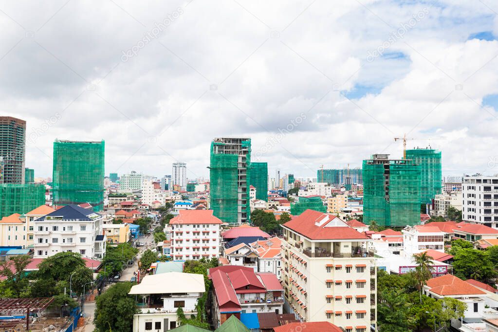 Image of Phnom Penh city. Contrast in architecture, big buildings, next to traditional houses. Construction industry.