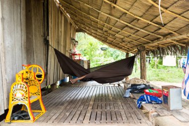 Phnom Penh, Phnom Penh / Kamboçya - 9 Ekim 2016: Kamboçya kırsal kesimin resmi. Ahşap kulübe. Yaşlı Khmer kadın hamakta dinleniyor..