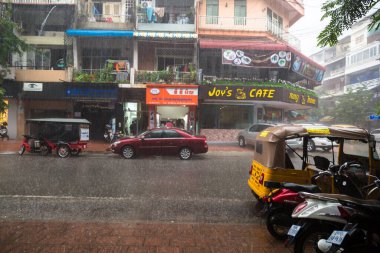 Phnom Penh, Phnom Penh / Kamboçya - 5 Ekim 2016: Kamboçya 'da yağmur mevsiminde apartman imajı. Sokaklar suyla dolu, alışveriş merkezlerinin önünde ulaşım var..