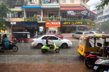 Phnom Penh, Phnom Penh / Kamboçya - 5 Ekim 2016: Kamboçya 'da yağmur mevsiminde apartman imajı. Sokaklar suyla dolu, alışveriş merkezlerinin önünde ulaşım var..