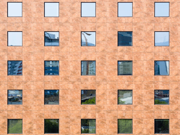 Image of frontal facade of building full of windows. Windows pattern in modern building.