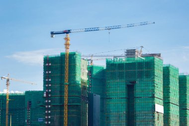 Çevresinde güvenlik ağı olan bir binanın görüntüsü. Yüksek binalar devam ediyor.