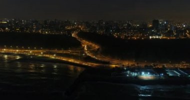 Gece Lima City Sahil Uçurumu 'nda İHA ile yapılan hava videosu. Geceleri Peru 'da Pasifik Okyanusu' nun yanındaki 