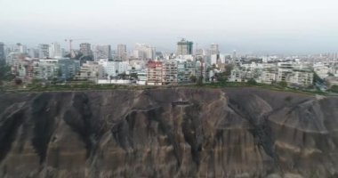 Öğleden sonra bulutlu bir günde Lima City sahil uçurumunda İHA ile yapılan hava hiperlapa videosu. Geceleri Peru 'da Pasifik Okyanusu' nun yanındaki 