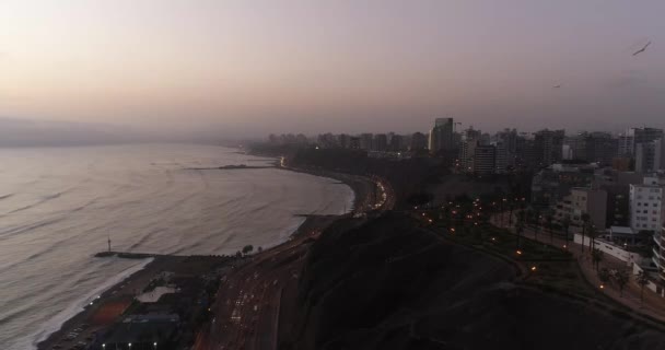 午後の曇りの日にリマ市の海岸の崖の上にドローンで作られた航空ハイパーラップビデオ ペルーの太平洋に隣接する コスタ ヴェルデ と呼ばれる夜の高速道路 — ストック動画