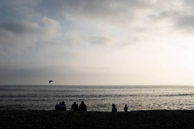Lima Peru sahilindeki insanların görüntüsü. İnsanlar çakıl taşı plajının tadını çıkarıyor. Pasifik Okyanusu.