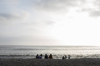 Lima Peru sahilindeki insanların görüntüsü. İnsanlar çakıl taşı plajının tadını çıkarıyor. Pasifik Okyanusu.