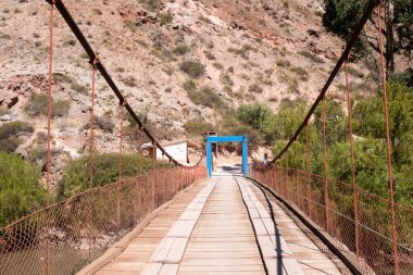 Urubamba Cusco 'daki Peru And Dağları' nda ahşaptan yapılmış bir kırsal köprü resmi. Kırsal yol Urubamba 'dan Maras' a nehri geçiyor..