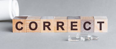 Doğru kelime siyah harflerle yazılmıştır tahta küplere, gri bsckground.