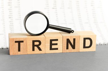 Tahta bloklar: büyüteçle trend. Yapı taşlarından yapılan trend kelimesi. İş konsepti