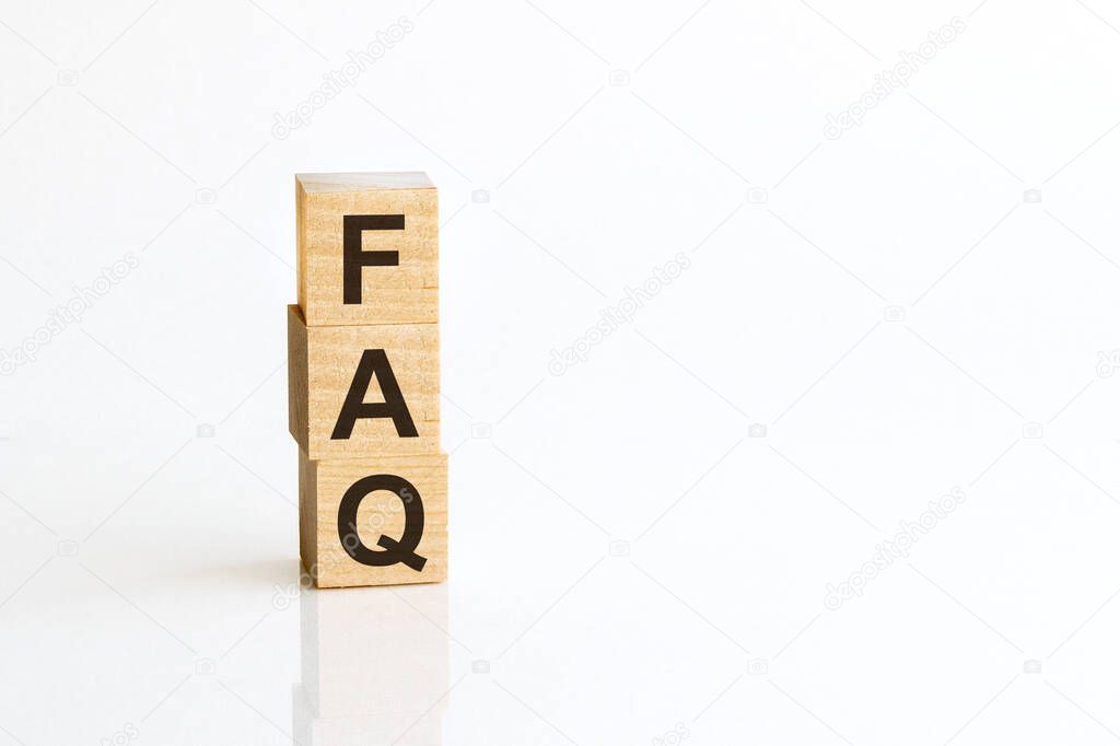 Three wooden cubes with letters FAQ - Frequently Asked Question - on white table, more in background, space for text in right down corner