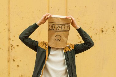 Çocuğun kafasında ırkçılık yok yazan bir poşet var.